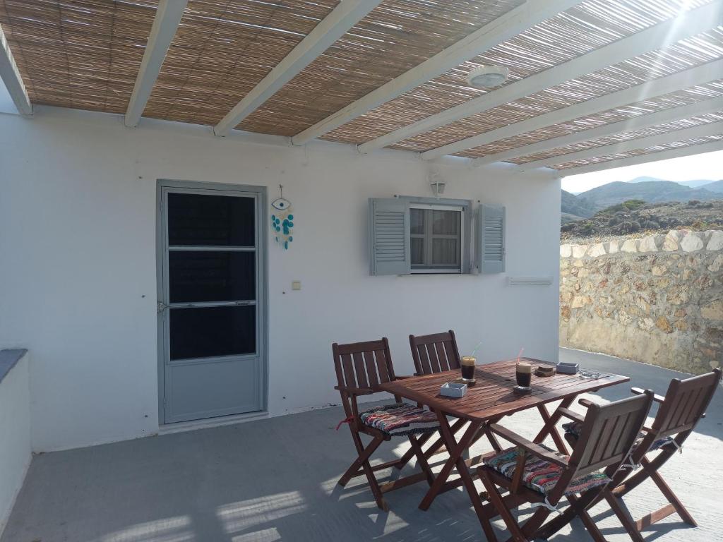a patio with a table and chairs and a window at Νύμφη in Kimolos