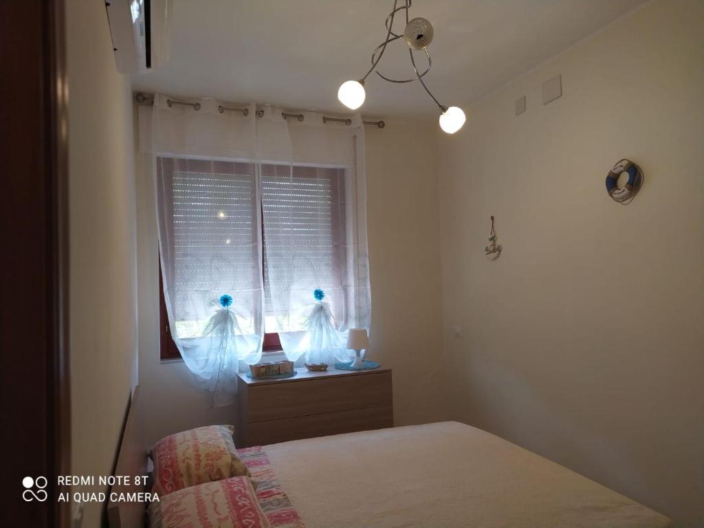 1 dormitorio con cama y ventana con luces en La casa di Fofo' e Ninetta en San Vito Chietino