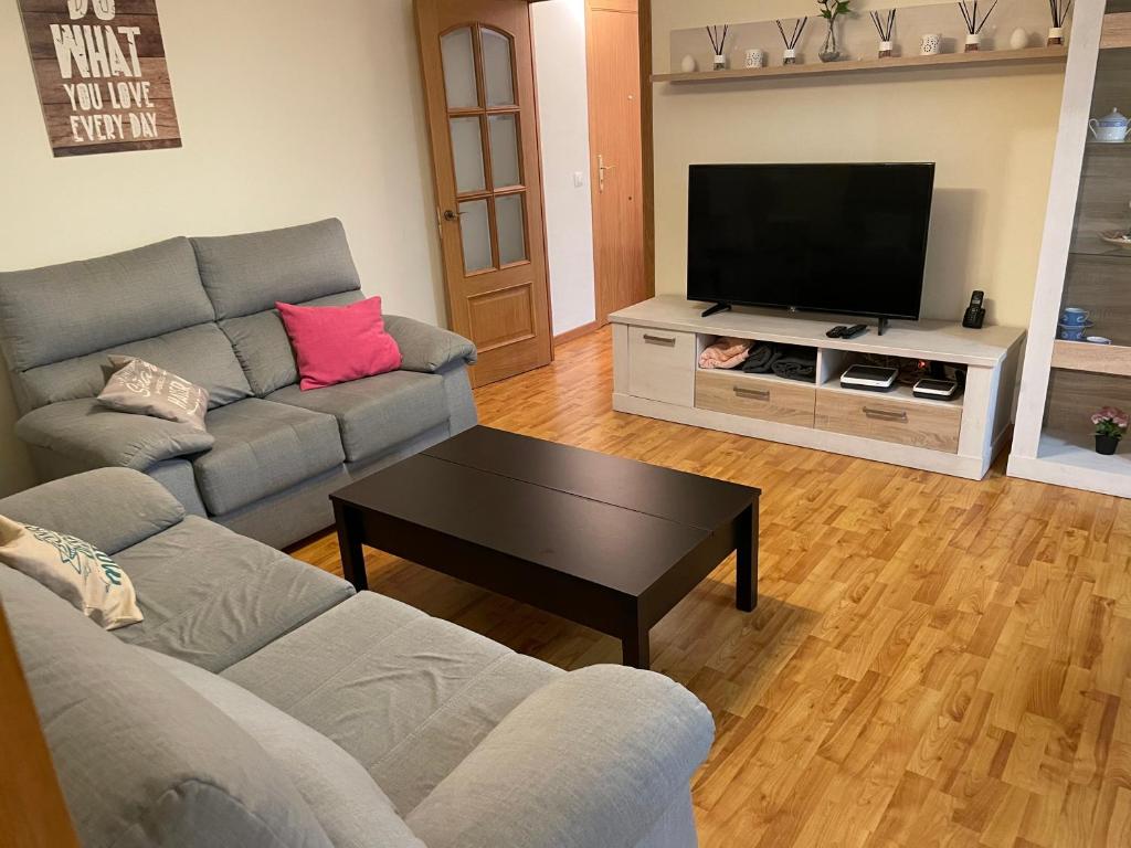 a living room with a couch and a flat screen tv at XRYHOMES I Residencial en Jerez 4 hab, 2 baños, 7pax, 10 min del centro in Jerez de la Frontera