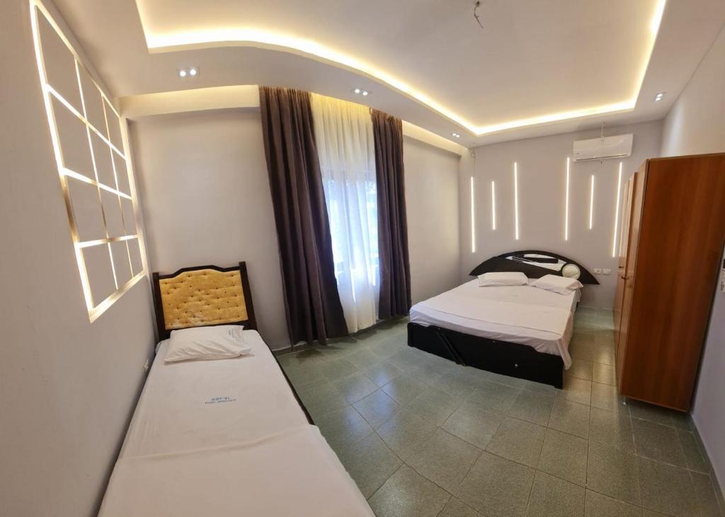 mały pokój z 2 łóżkami i oknem w obiekcie Hotel Dragoi w mieście Velipoja
