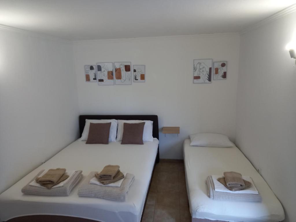 2 Betten in einem weißen Zimmer mit Handtüchern darauf in der Unterkunft Apartman Dardic in Herceg-Novi