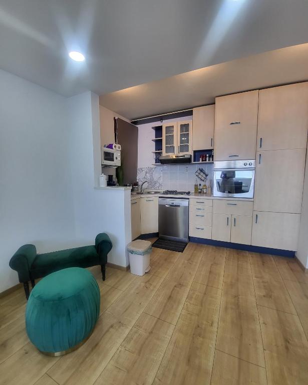 uma cozinha com armários brancos e um repousa-pés verde em Luxury Penthouse Residence Kasandra em Jesenice
