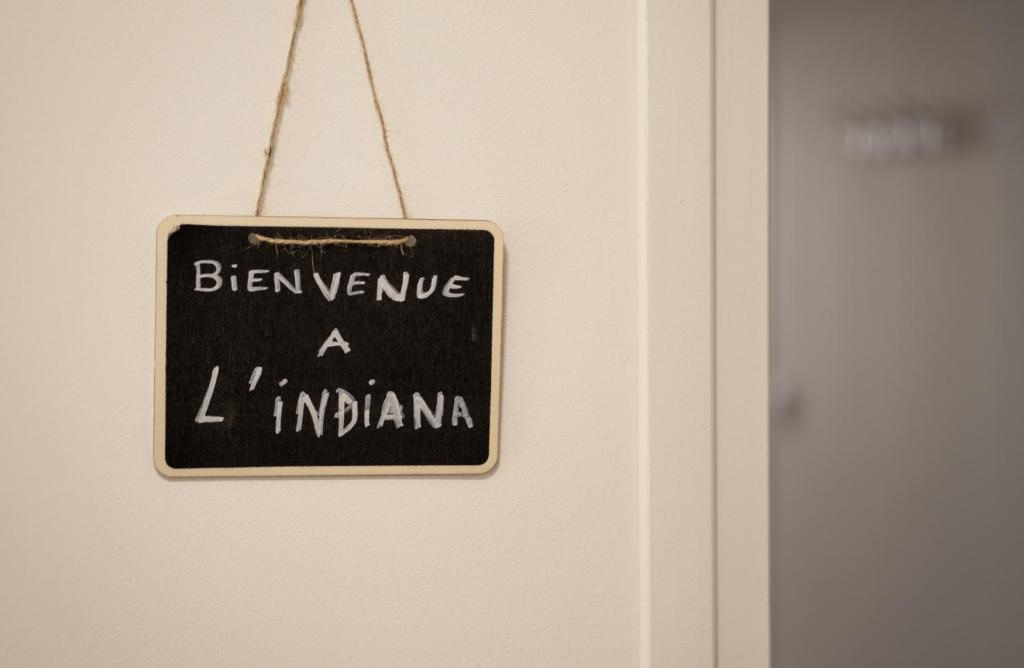 Un cartel en una puerta que dice "Cuidado a la indiana" en Nouveau - L'indiana - Jardin partagé, barbecue en Diemeringen