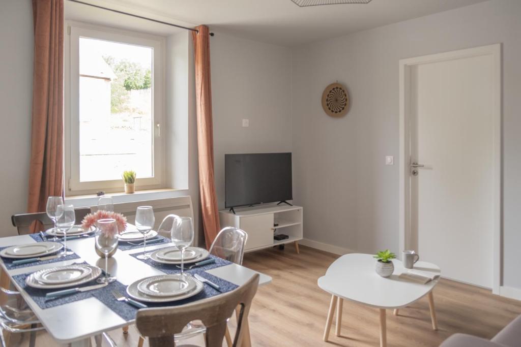 une salle à manger avec une table et une télévision dans l'établissement Nouveau - L'Univers - Jardin partagé, barbecue, à Diemeringen