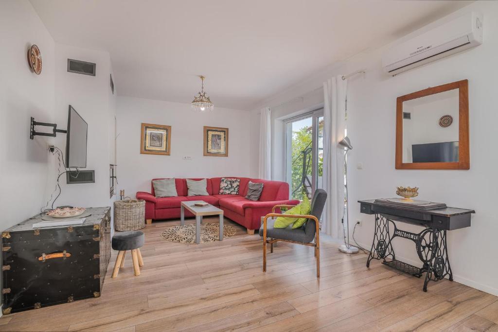 salon z czerwoną kanapą i stołem w obiekcie House Tonica with pool w mieście Malinska