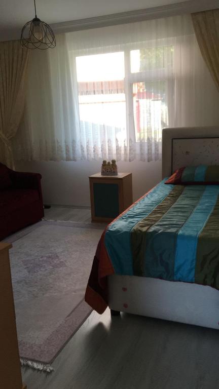 sypialnia z łóżkiem i oknem w obiekcie AYDIN APART. w mieście Arsin