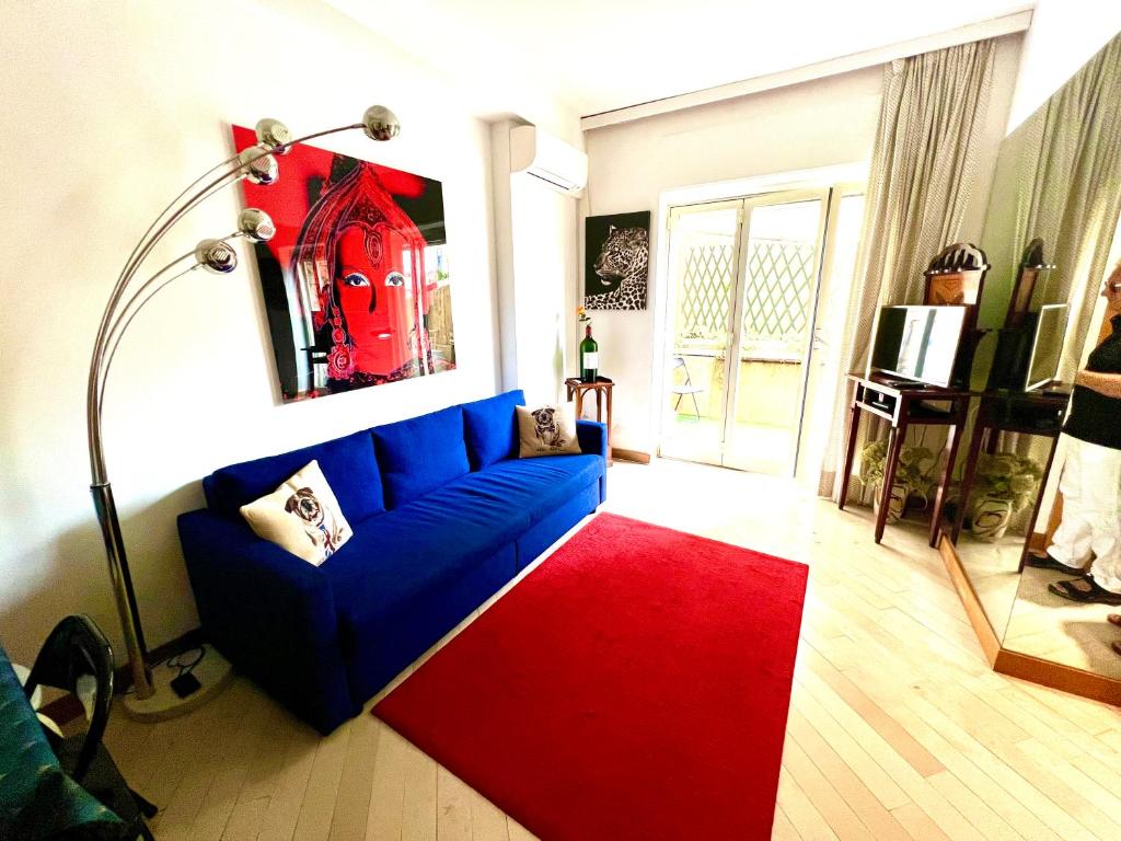 a living room with a blue couch and a red rug at Very Central suite apartment with 1bedroom next to train station Monaco and 6min from casino place in Monte Carlo