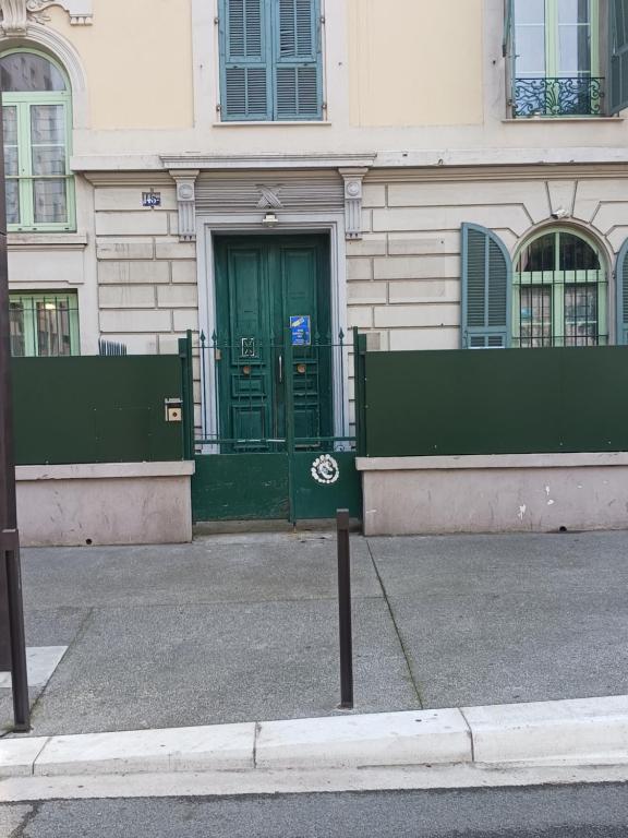 a building with a green door on a street at studio à 2 mn à pied de la plage in Nice