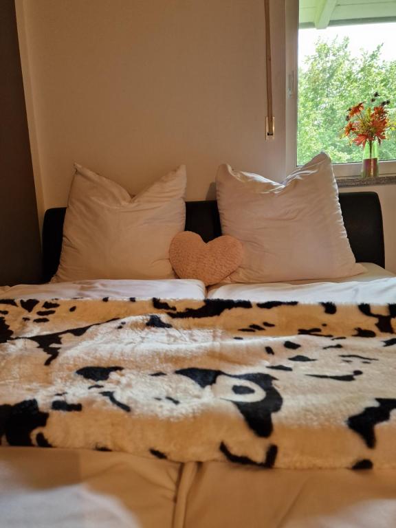 1 dormitorio con 2 camas y manta de vaca en Ferienwohnung Bayernbrise, en Rohrdorf