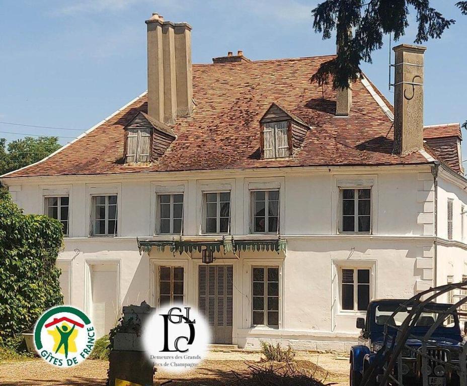ein weißes Haus mit einem Schild davor in der Unterkunft Demeures des grands lacs de champagne in Brienne-le-Château