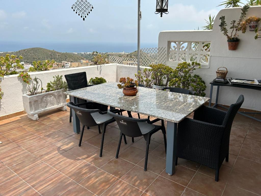 uma mesa e cadeiras num pátio com vista em Apartment with a great terrace, sea and land views em Mojácar