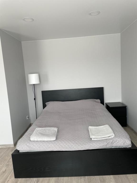 een slaapkamer met een bed met twee handdoeken erop bij TK apartamenti in Rēzekne