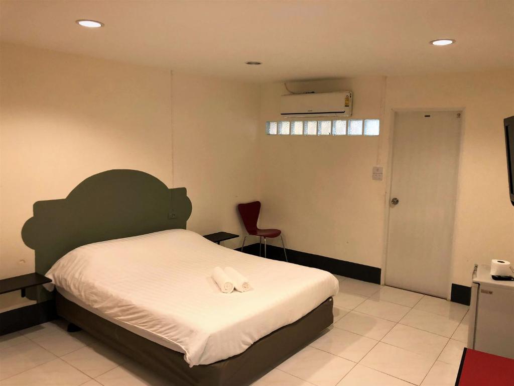 een slaapkamer met een bed en een rode stoel bij City Inn Udonthani in Udon Thani