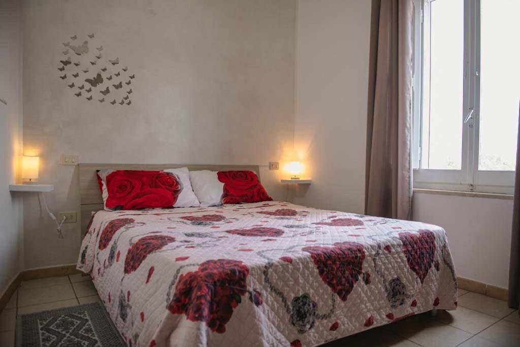 Un dormitorio con una cama con almohadas rojas. en Casa Vacanze Le Cascate en Le Marmore