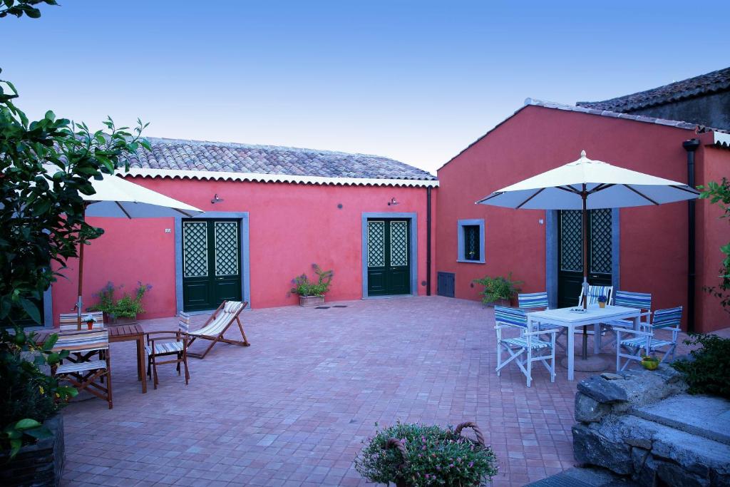 a patio with tables and chairs and an umbrella at Lumia in Riposto