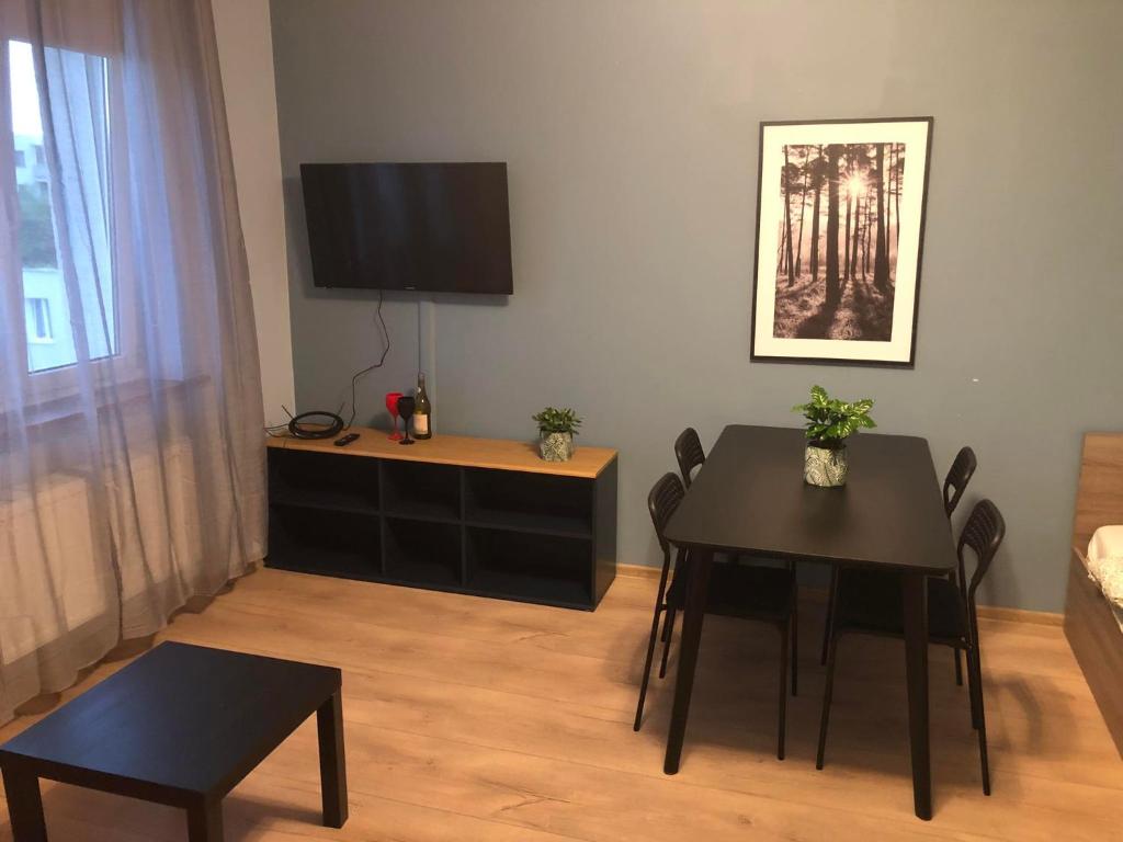 a living room with a dining room table and a television at Apartament Zwirki i Wigury 38 in Bydgoszcz