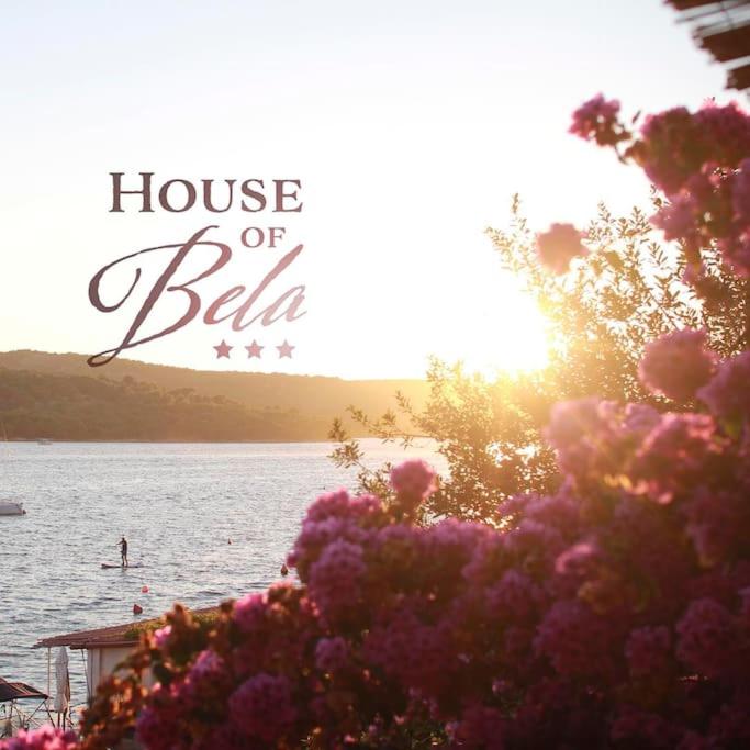 a sign that says house of bella with flowers at Small house at seafront in Tisno
