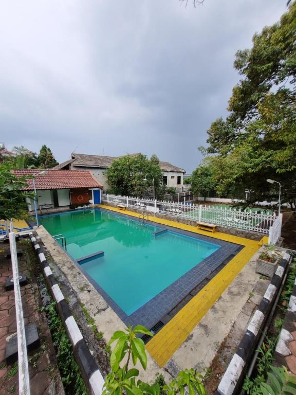 una gran piscina de agua azul en un patio en Villa Edelweis, en Pasuruan