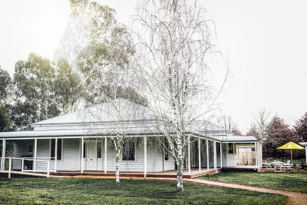 uma casa branca com duas árvores no quintal em Dal Zotto Homestead & Studios em Whitfield