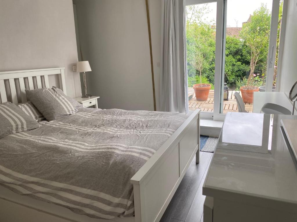 sypialnia z łóżkiem i widokiem na patio w obiekcie Grande chambre + chambre d'appoint w mieście Ronchin