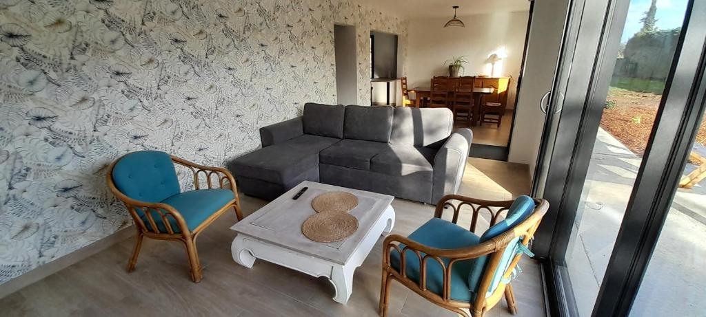a living room with a couch and a table and chairs at Maison à L' arcouest proche embarcadere Bréhat in Ploubazlanec