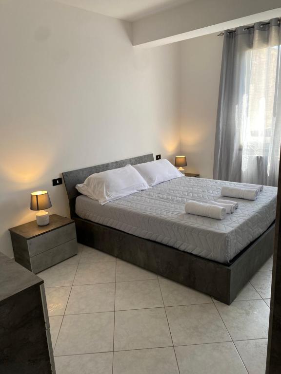 a bedroom with a large bed with two tables and two lamps at [la terrazza del sole] in Menfi