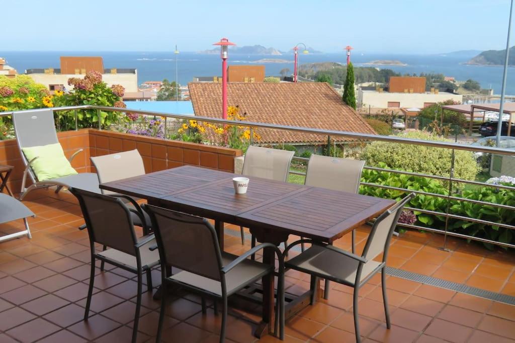 een tafel en stoelen op een balkon met uitzicht bij Vistas magnificas Islas Atlanticas in Baiona