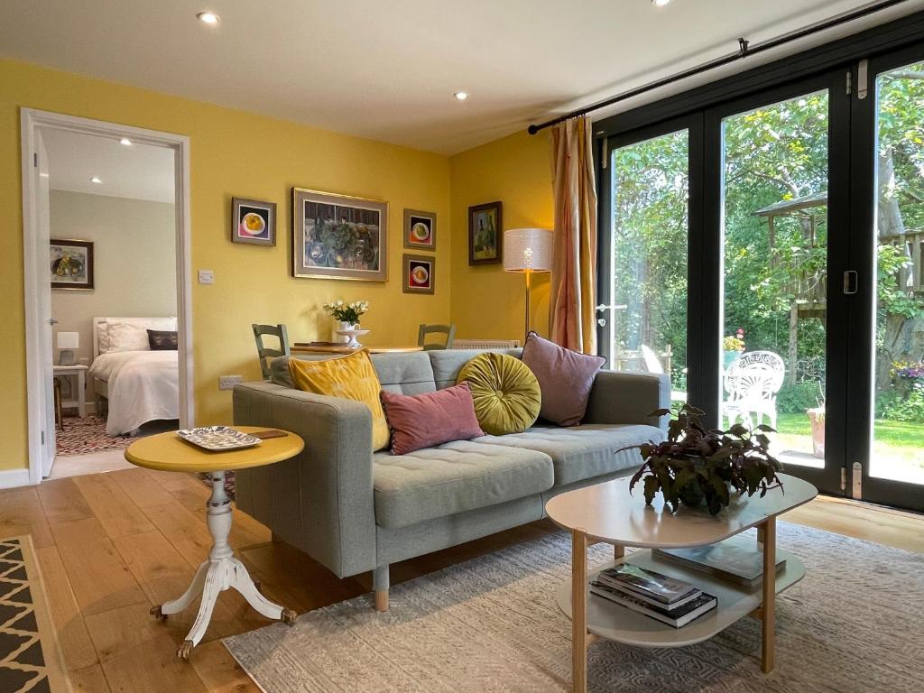 a living room with a couch and a table at Garden hideaway, self-contained, edge of Bath in Bath