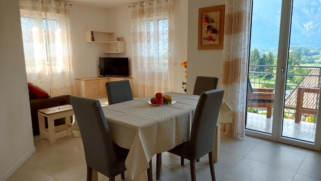 una sala da pranzo con tavolo, sedie e TV di Ca Giardina CIPAT 022104-AT-012586 a Levico Terme