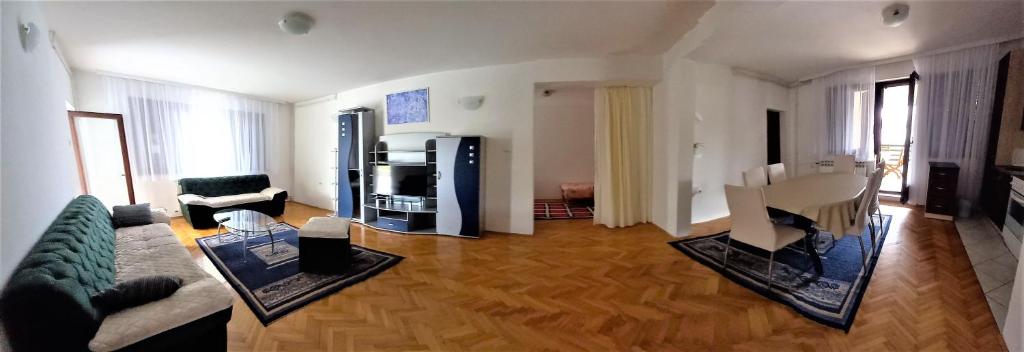 uma sala de estar com um sofá e uma mesa em Bonem 4 apartman Gradiška em Bosanska Gradiska