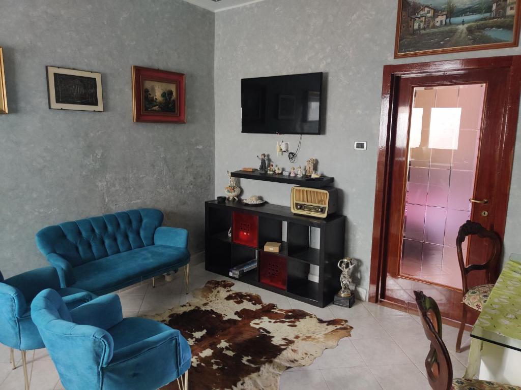 a living room with blue chairs and a tv at Keur Magatte in Saint-Louis