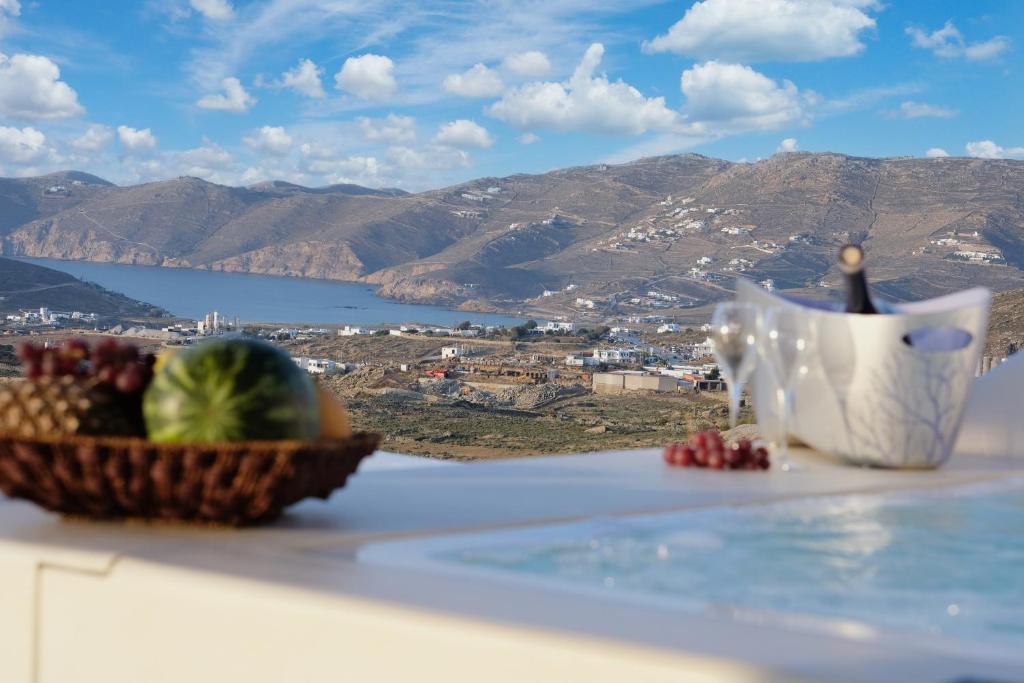 a bowl of fruit on a table with a view of mountains at Villa Ktima Lipsi - Jacuzzi & Stunning Sea Sunsets in Klouvas