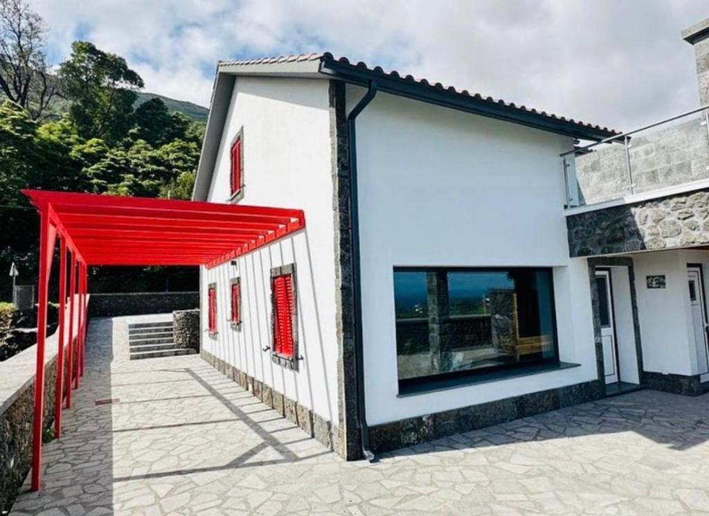 Adega do Cagarro في براينا جي بايْشو: مبنى ابيض صغير عليه ساتر احمر