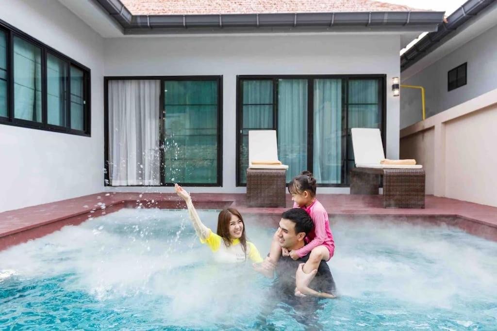 um grupo de crianças a brincar numa piscina em Private Pool villa & warm water. em Ban Mae Kon
