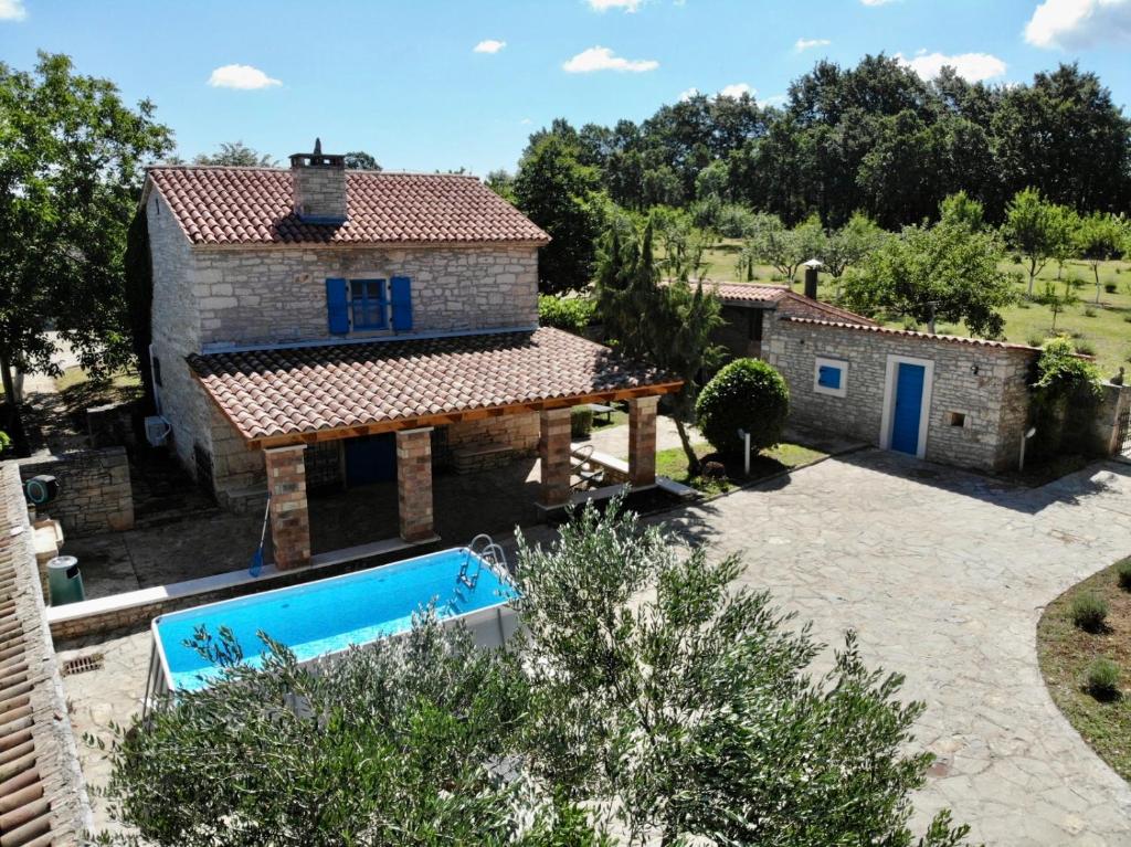 een extern uitzicht op een huis met een zwembad bij Family-sized renovated Istrian house w/lavand field - 20min from Rovinj. in Žminj