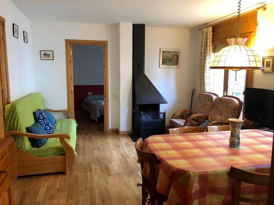 sala de estar con mesa y chimenea en Apartament al cor de la Vall de Camprodon, en Vilallonga de Ter