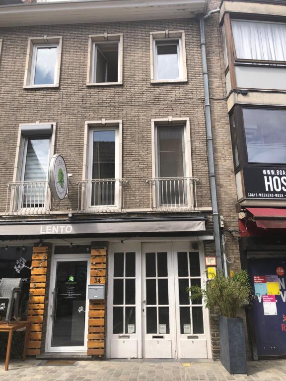 een bakstenen gebouw met witte deuren op een straat bij Cozy studio in Hasselt in Hasselt