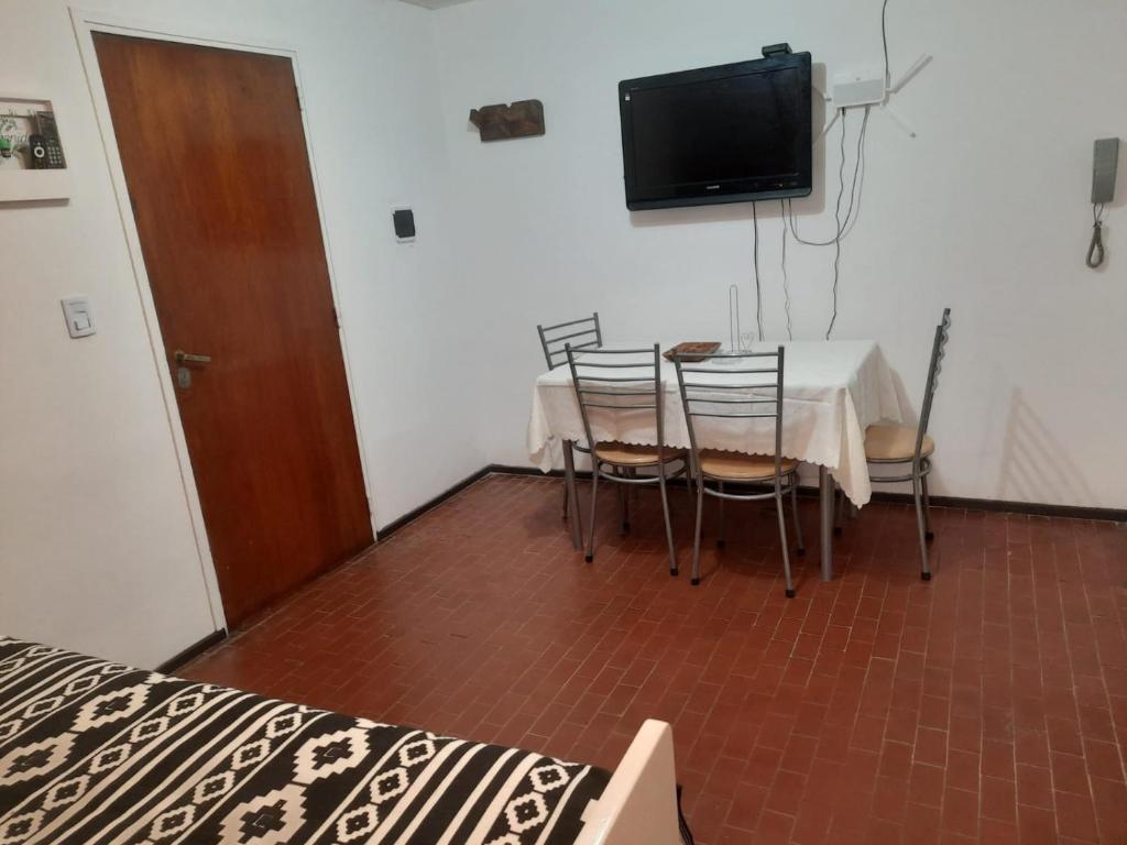 a dining room with a table and chairs and a television at CONSORCIO ARIZU in Mendoza