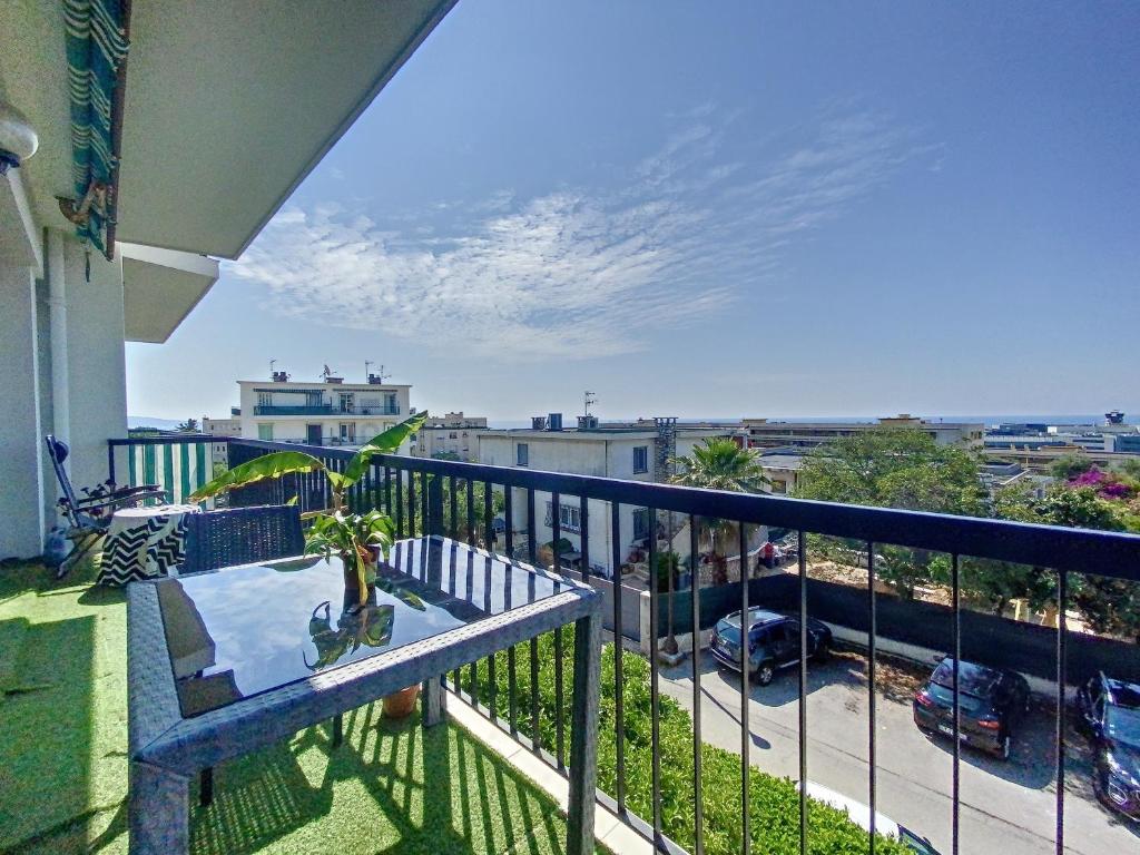 un balcon avec une table et une vue sur une ville dans l'établissement *Confort, Vue Mer et Détente*, à Nice