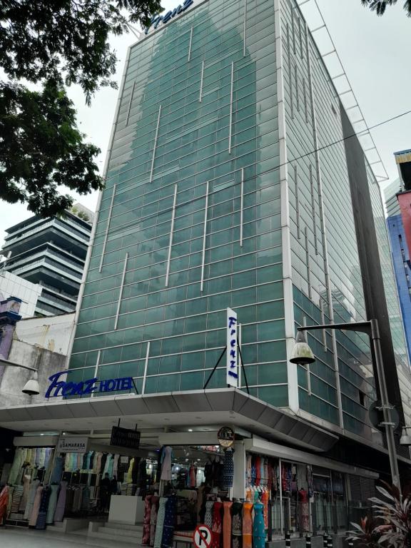 a tall glass building with a store in front of it at Frenz Hotel Kuala Lumpur in Kuala Lumpur