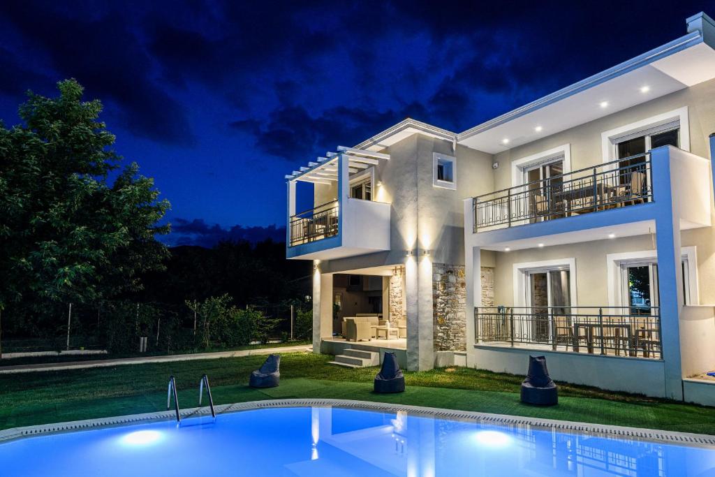 una casa grande con piscina frente a ella en Sunny Memories Apartments, en Limenas