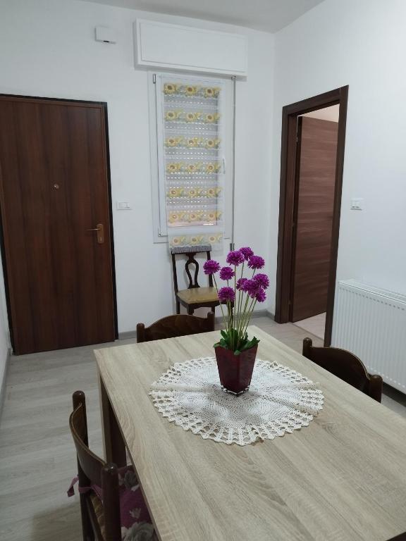 a table with a vase with purple flowers on it at Da Silvana in Rovereto