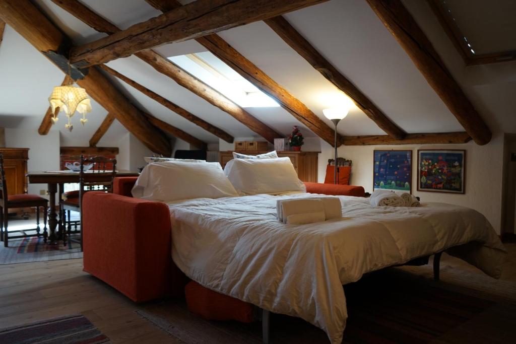 a bedroom with a large bed and a dining room at Appartamento Les Cimes in Bardonecchia