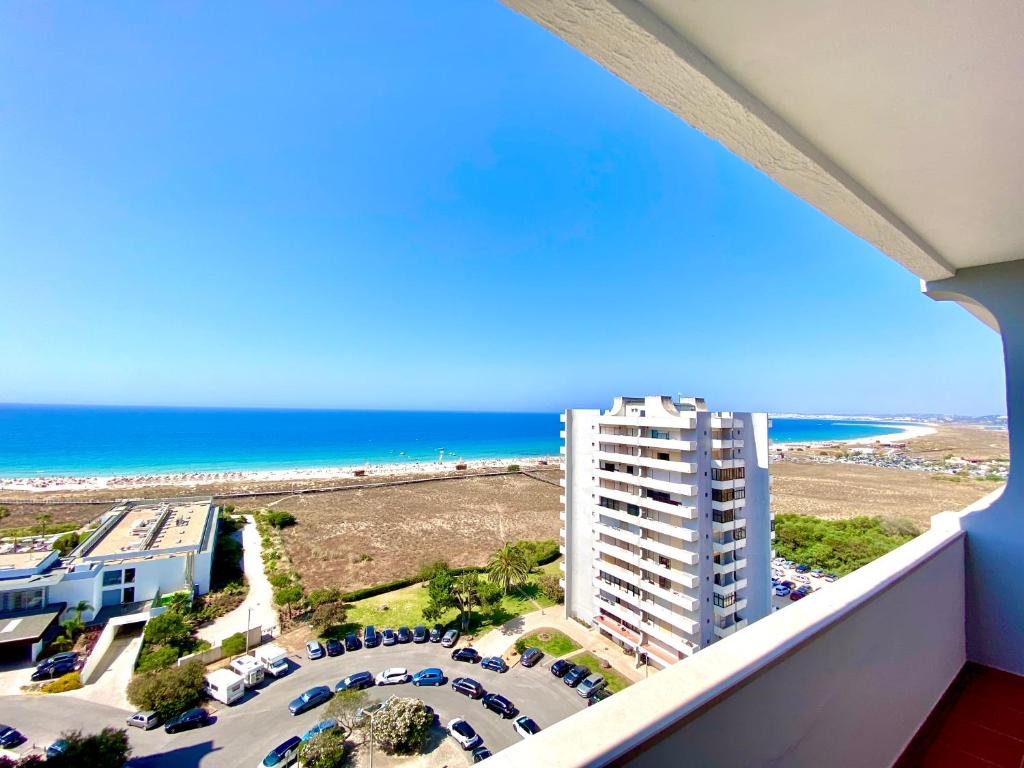 a balcony with a view of a beach and a building at Alvor Seven 10 in Alvor