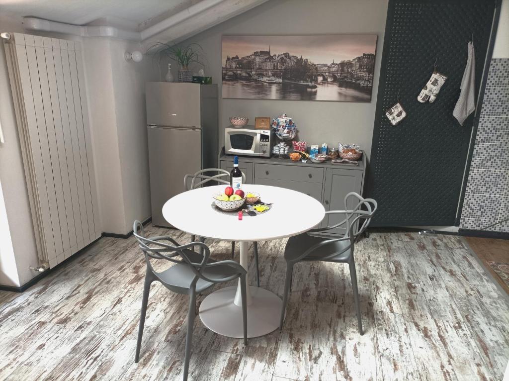eine kleine Küche mit einem weißen Tisch und Stühlen in der Unterkunft La petite maison de Claire in Cuneo