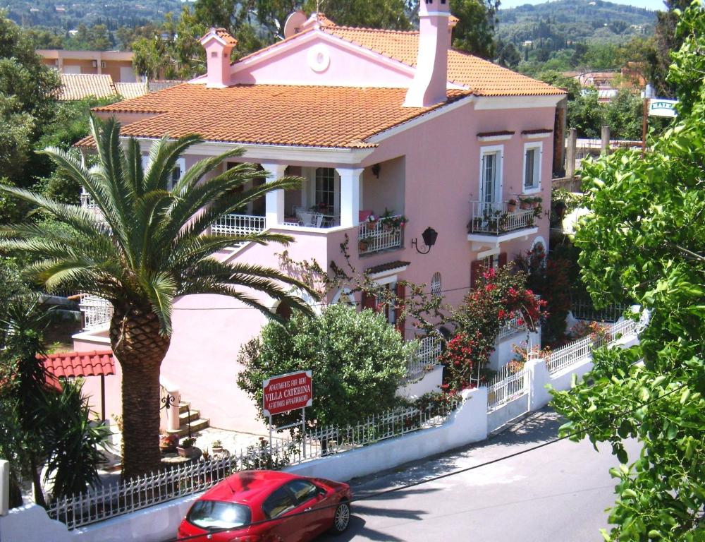 una casa con un coche rojo estacionado frente a ella en Villa Caterina, en Ýpsos