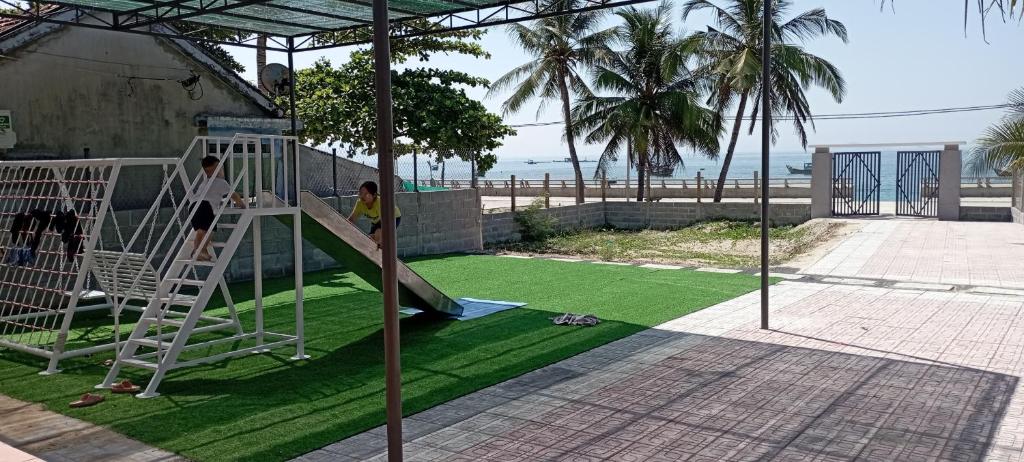 a childrens playground with a slide and grass at Villa mặt biển - bờ kè Đông Hải in Ninh Hòa