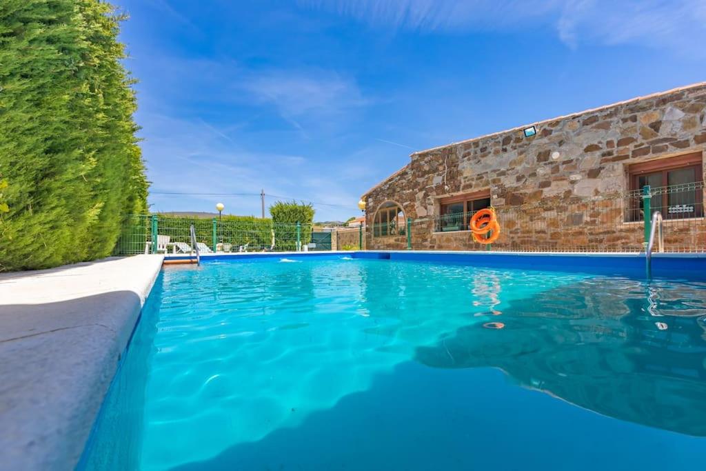 a swimming pool with blue water in front of a building at Chalet con piscina privada en Bolonia in Tarifa