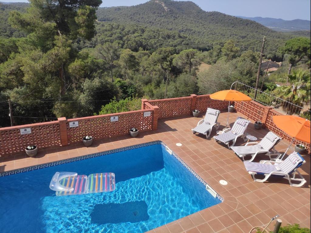 una piscina con sillas y sombrillas en un patio en Casa aire, en Pals