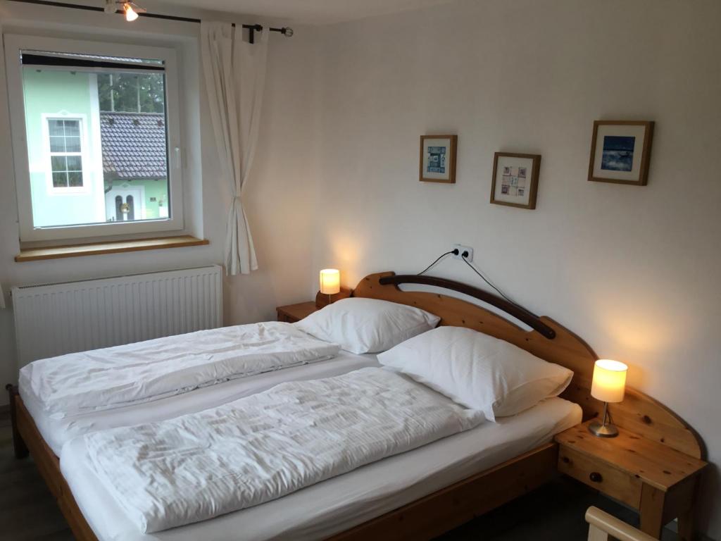 a bedroom with a bed and a window and two lamps at Haus Schmid Mattsee in Mattsee